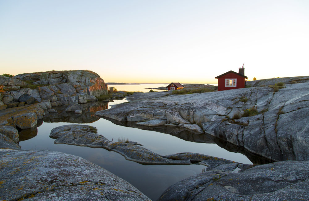 Soluppgång över Skärgårdskobbe Med Små Stugor Soluppgång över skärgårdskobbe med små stugor